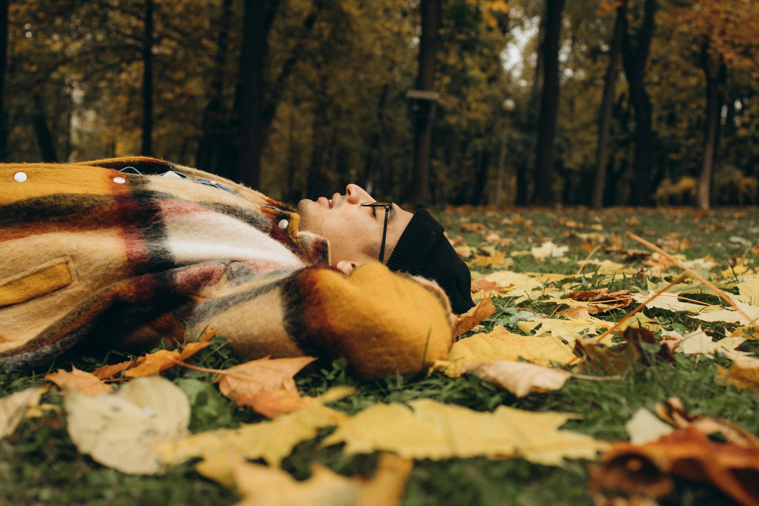 Person relaxing in autumn leaves